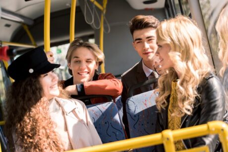 happy-young-friends-talking-while-sitting-in-city-bus.jpg