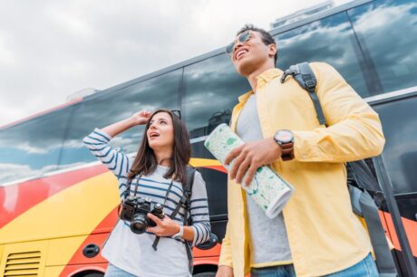 woman-holding-digital-camera-and-looking-away-with-mixed-race-man-holding-map-near-travel-bus.jpg